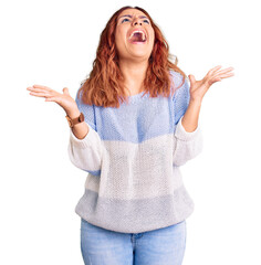 Young latin woman wearing casual clothes crazy and mad shouting and yelling with aggressive expression and arms raised. frustration concept.