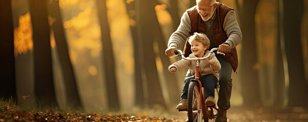 Happy grandfather teach cycling a child in park, wide banner - obrazy, fototapety, plakaty