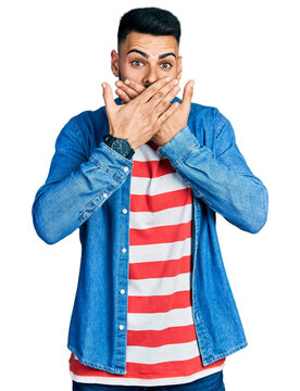 Young hispanic man with beard wearing casual denim jacket shocked covering mouth with hands for mistake. secret concept.