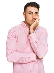 Hispanic young man wearing casual clothes thinking looking tired and bored with depression problems with crossed arms.