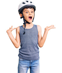 Little cute boy kid wearing bike helmet celebrating victory with happy smile and winner expression...