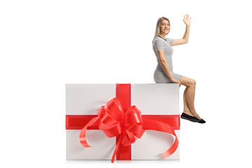 Young woman sitting on a big present box