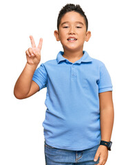Little boy hispanic kid wearing casual clothes smiling looking to the camera showing fingers doing victory sign. number two.