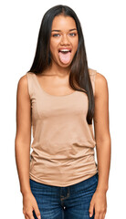 Fototapeta premium Beautiful hispanic woman wearing casual clothes sticking tongue out happy with funny expression. emotion concept.