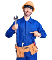 Gardinen Young hispanic man wearing electrician uniform holding wrench pointing finger to one self smiling happy and proud © Krakenimages.com