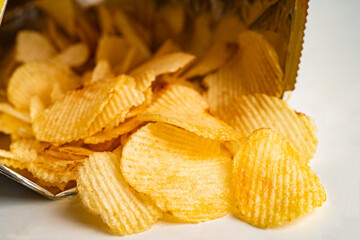 Potato chips, delicious BBQ seasoning spicy for crips, thin slice deep fried snack fast food in open bag.
