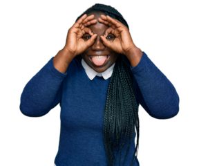 Young black woman with braids wearing casual clothes doing ok gesture like binoculars sticking tongue out, eyes looking through fingers. crazy expression.