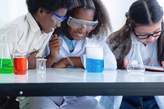 Group of students in science lab, studying science, doing a chemical experiment in laboratory at school