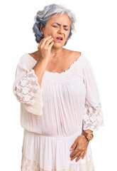 Senior woman with gray hair wearing bohemian style touching mouth with hand with painful expression because of toothache or dental illness on teeth. dentist