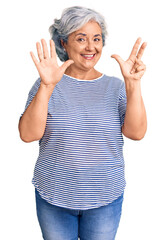 Senior woman with gray hair wearing casual striped clothes showing and pointing up with fingers number eight while smiling confident and happy.