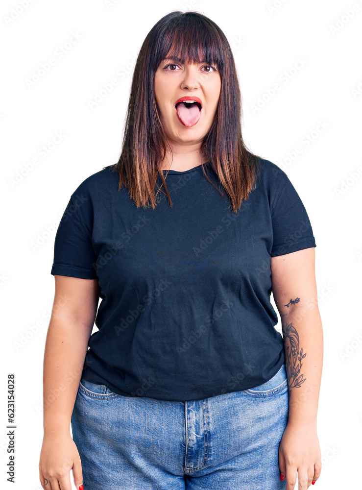 Poster young plus size woman wearing casual clothes sticking tongue out happy with funny expression. emotio