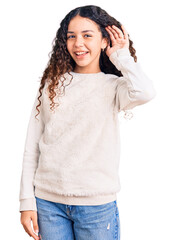 Fototapeta premium Beautiful kid girl with curly hair wearing casual clothes smiling with hand over ear listening an hearing to rumor or gossip. deafness concept.
