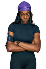 Young african american woman wearing sportswear skeptic and nervous, disapproving expression on face with crossed arms. negative person.