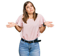 Beautiful caucasian woman wearing casual clothes clueless and confused expression with arms and...