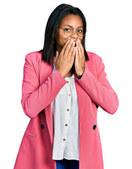 Beautiful hispanic woman wearing business jacket laughing and embarrassed giggle covering mouth...