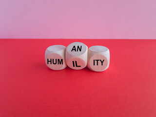 Humility vs humanity symbol. Turned cubes and changed the word 'humility' to 'humanity'. Beautiful red table, pink background, copy space. Business and humility vs humanity concept