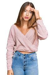 Fototapeta premium Beautiful blonde woman wearing casual winter pink sweater worried and stressed about a problem with hand on forehead, nervous and anxious for crisis