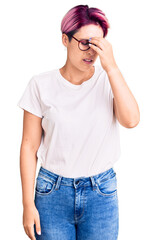 Young beautiful woman with pink hair wearing casual clothes and glasses tired rubbing nose and eyes feeling fatigue and headache. stress and frustration concept.