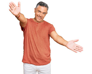 Handsome middle age man wearing casual clothes looking at the camera smiling with open arms for...
