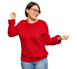 Young beautiful hispanic woman with short hair wearing casual sweater and glasses dancing happy and cheerful, smiling moving casual and confident listening to music