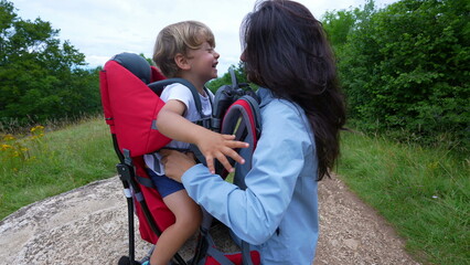 Happy mother and child laughing and smiling together while hiking