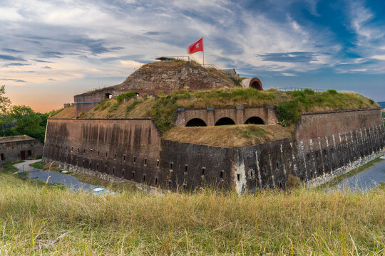 The medieval fortress in Maastricht strategically located on the slopes of the Sint Pietersberg hill during a spectacular sunset with a dramatic sky and rays of sun.