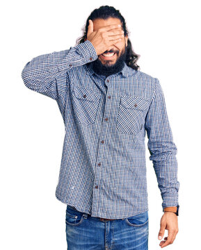 Young arab man wearing casual clothes smiling and laughing with hand on face covering eyes for surprise. blind concept.