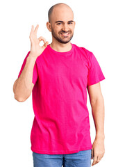 Young handsome man wearing casual t shirt smiling positive doing ok sign with hand and fingers. successful expression.