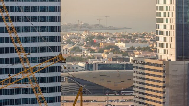 Skyscrapers and privat houses near Business Bay Metro Station alongside Sheikh Zayed Road in Dubai timelapse. Areial view with cranes on construction site
