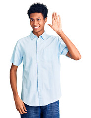 Young african american man wearing casual clothes waiving saying hello happy and smiling, friendly welcome gesture © Krakenimages.com