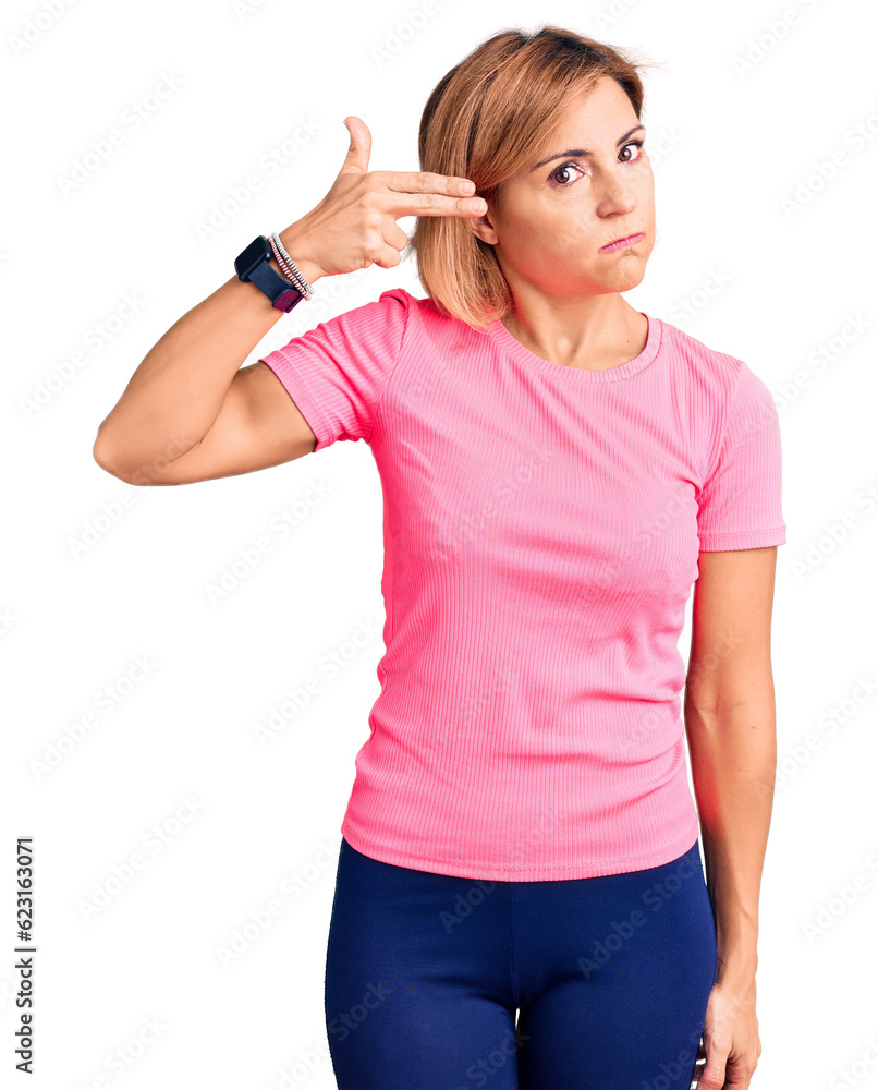 Poster young blonde woman wearing sportswear shooting and killing oneself pointing hand and fingers to head