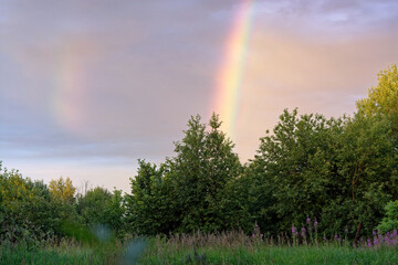 Rainbow in the village against the background of a rural house