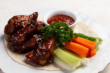 Fried chicken wings with vegetables.