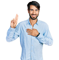 Hispanic man with blue eyes wearing business shirt smiling swearing with hand on chest and fingers...