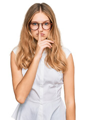 Beautiful young caucasian girl wearing casual clothes and glasses asking to be quiet with finger on lips. silence and secret concept.