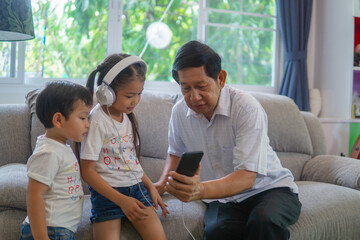 Fototapeta premium Grandfather and grandson playing video game at sofa.
