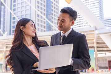 Happy businessman and businesswoman hands hold laptop outdoor.