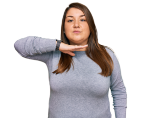 Beautiful brunette plus size woman wearing casual clothes cutting throat with hand as knife, threaten aggression with furious violence