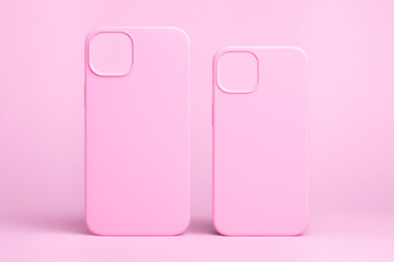 set of two pink cases for iPhone 15 and 14 Plus or iPhone 13 and 13 mini back view isolated on pink...