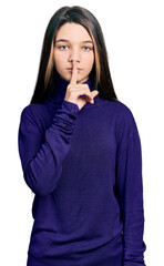 Young brunette girl with long hair wearing turtleneck sweater asking to be quiet with finger on lips. silence and secret concept.