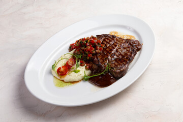 T-bone steak and mashed potatoes in a plate.