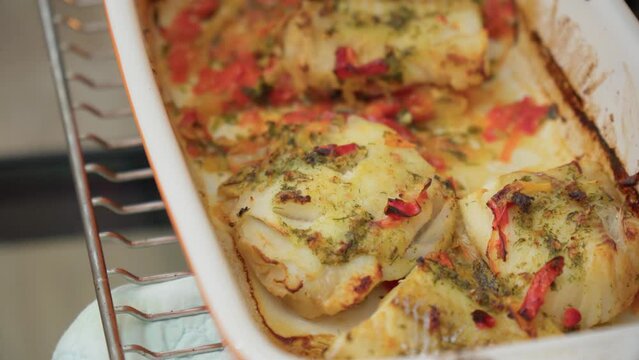 Baked cod fish served in bowl. Cooking fish in the oven. Selective focus.