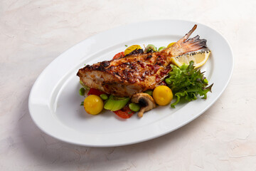 Grilled perch in a bowl. On a light background.