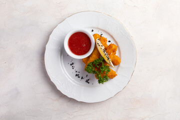 Fried cheese sticks in a bowl. On a light background.