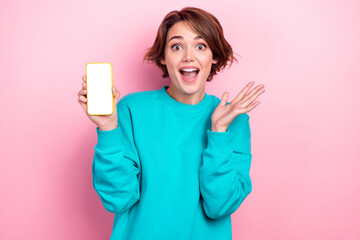 Portrait of astonished cheerful girl wear stylish teal jumper celebrates low price modern device...