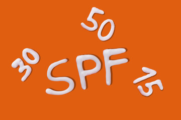 SPF cream. Sunscreen cream on orange background. Creative idea of suntan lotion cream. Sun ultraviolet protection concept.
