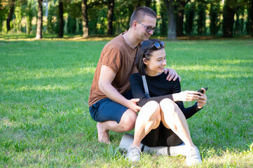 couple watching mobile device outdoor. Positive, happy, Honey lovely smiling fit family. fun browsing Internet