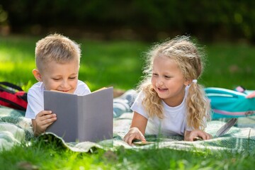 Happy little children's reading books in park