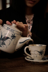 Classic Japanese pouring tea from pot to cup in a dark atmosphere tea room