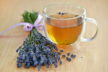 Cup of tea and lavender flowers on a wooden table - 623184263